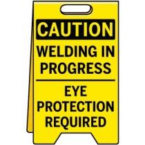 Caution sign warning of welding in progress and the need for eye protection.