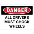 Safety sign warning drivers to chock wheels with a red border and black text.