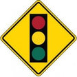 Warning sign indicating a traffic light ahead on a yellow background