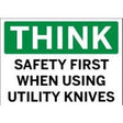 Safety sign with text 'THINK SAFETY FIRST WHEN USING UTILITY KNIVES' on a green background