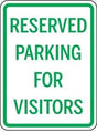 Reserved parking for visitors sign with green text on a white background