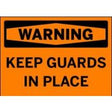 Orange warning sign with black text 'WARNING KEEP GUARDS IN PLACE'.