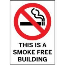 No smoking symbol above the text “This is a Smoke-Free Building” on a white sign