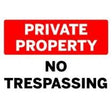Red and white 'Private Property No Trespassing' sign on a black background
