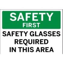 Safety sign with 'Safety First' and 'Safety Glasses Required In This Area' text on a green and white background.