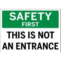 Safety sign with text 'SAFETY FIRST THIS IS NOT AN ENTRANCE' on a white background