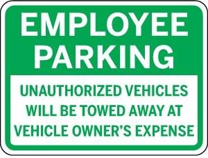 Green sign with 'Employee Parking' text and warning about unauthorized vehicles.