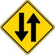 Yellow traffic sign with black arrows indicating a merge.