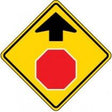 Road sign with a red stop symbol and black arrow on a yellow background
